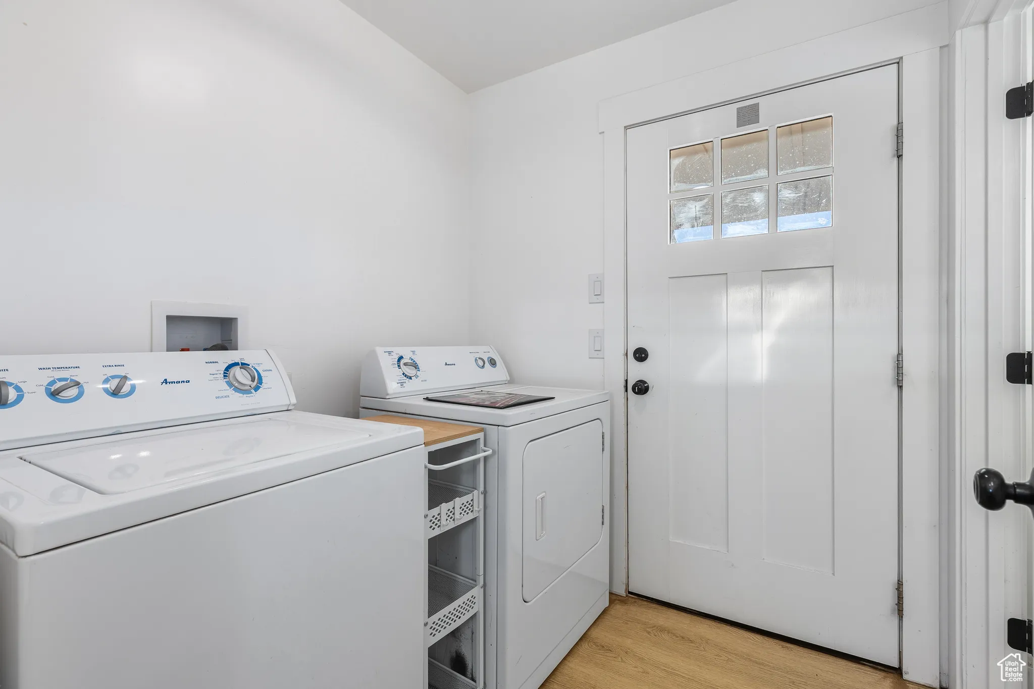 Laundry area featuring light wood-type flooring and washing machine and clothes dryer