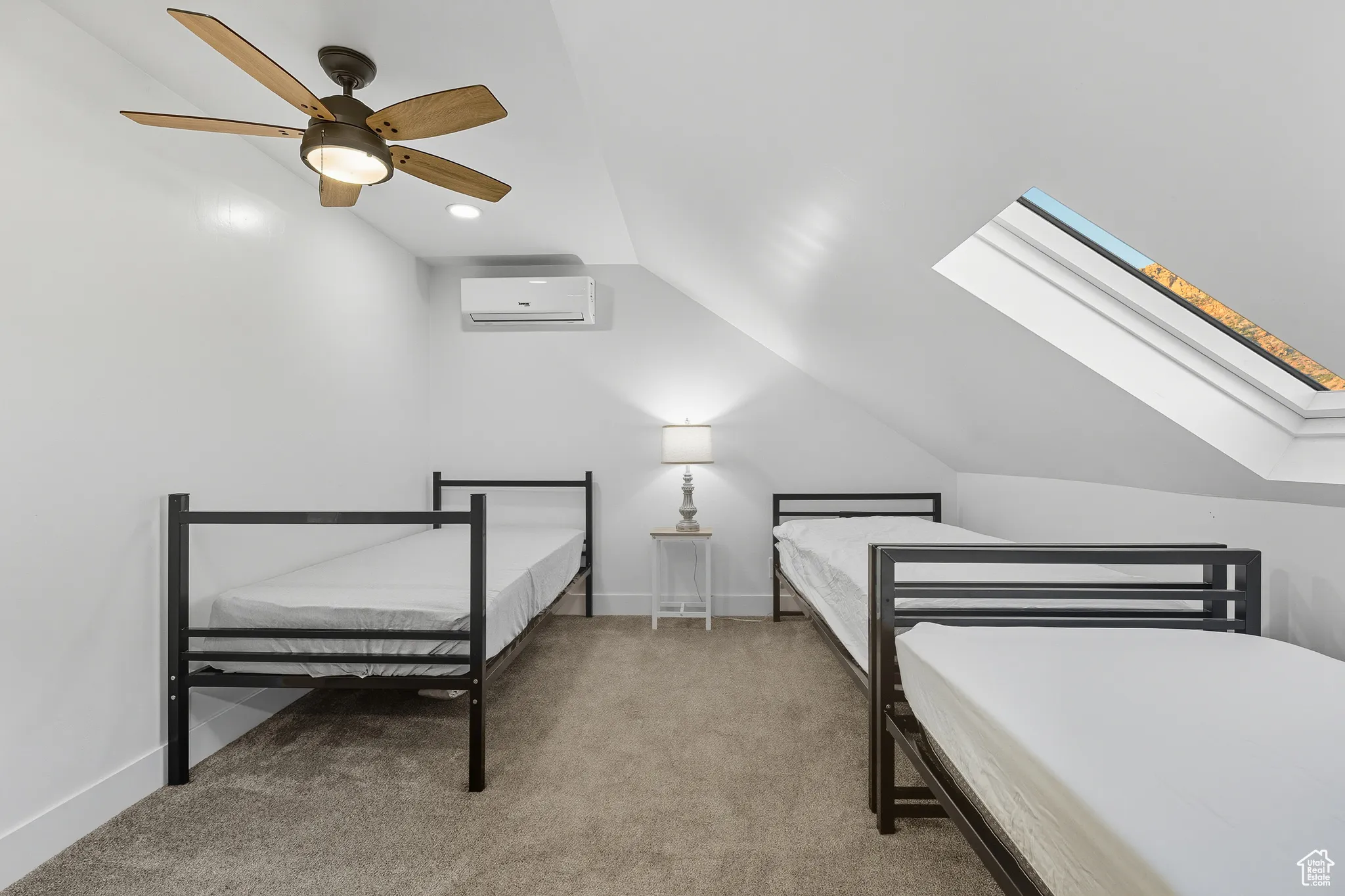 Bedroom with vaulted ceiling, light colored carpet, ceiling fan, a skylight, and recessed lighting