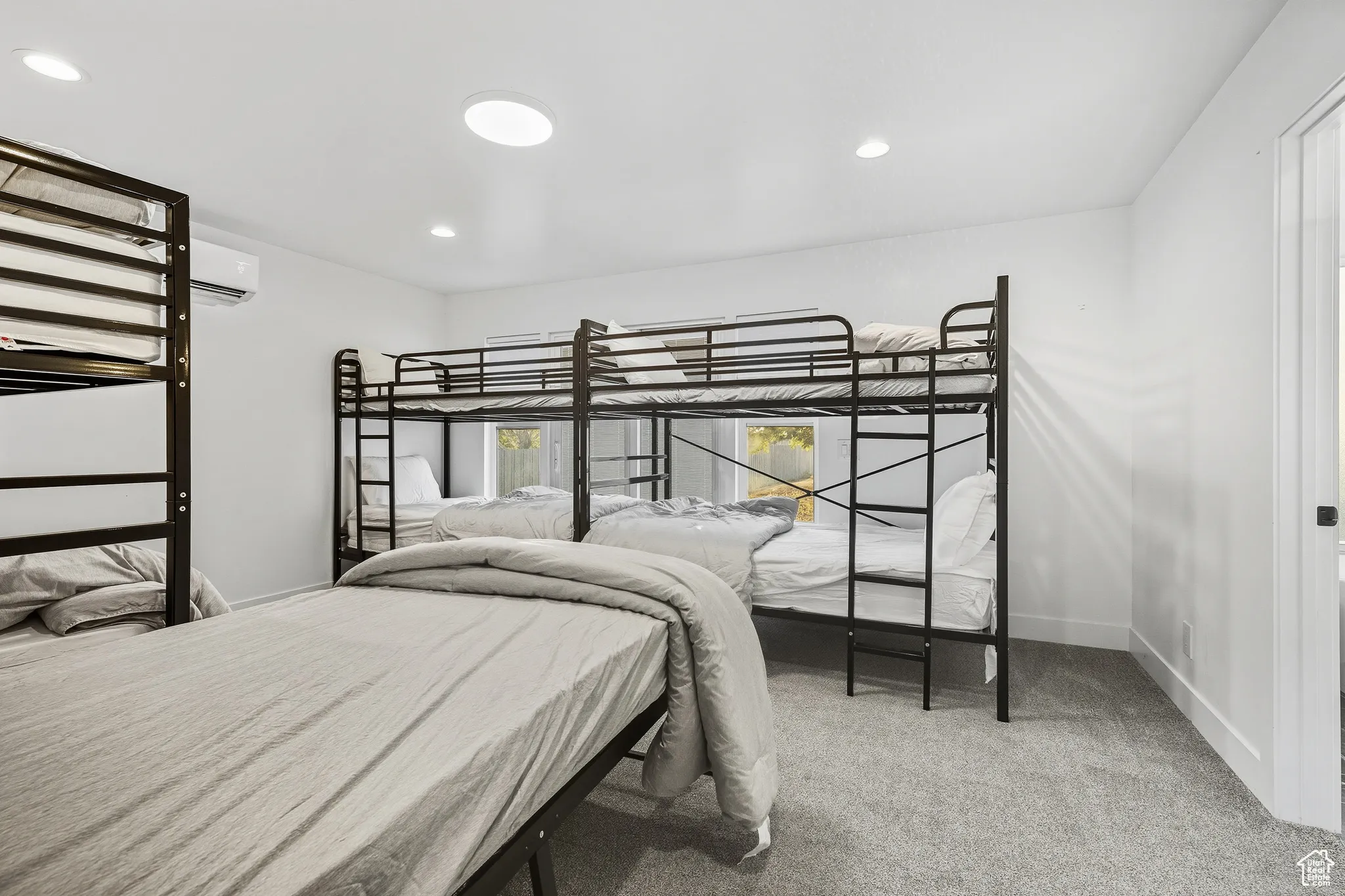 Bedroom featuring recessed lighting, light carpet, and an AC wall unit