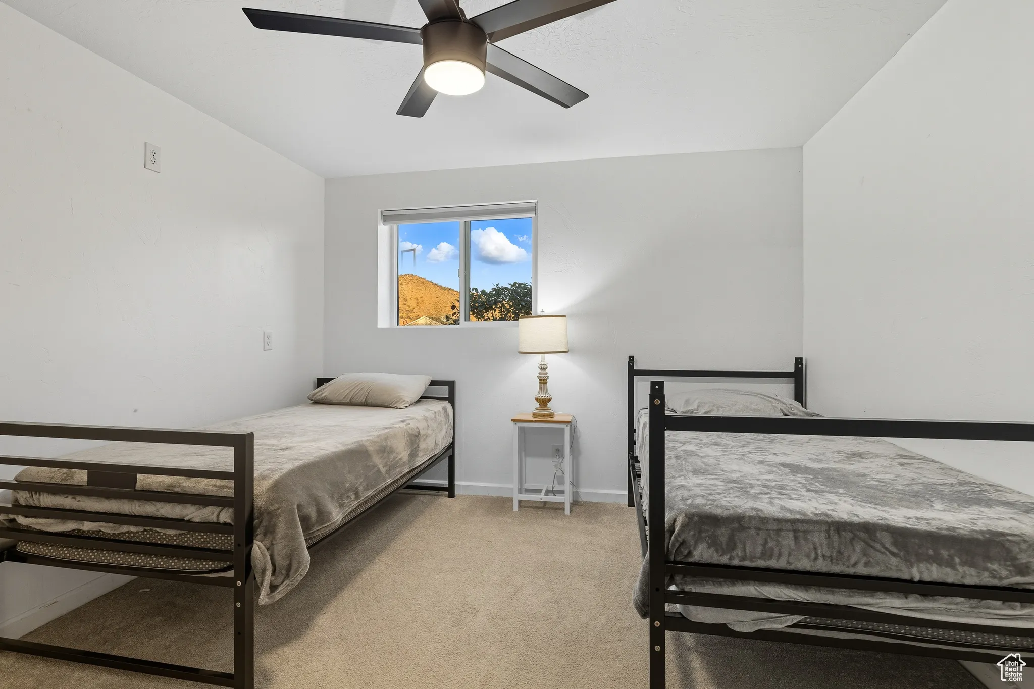 Bedroom with light carpet and a ceiling fan