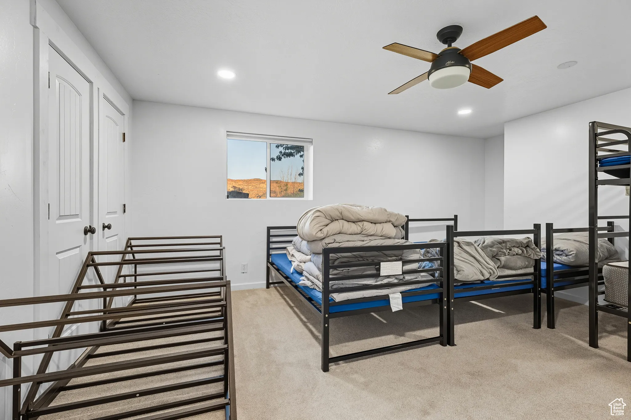 Bedroom with light colored carpet, recessed lighting, and a ceiling fan
