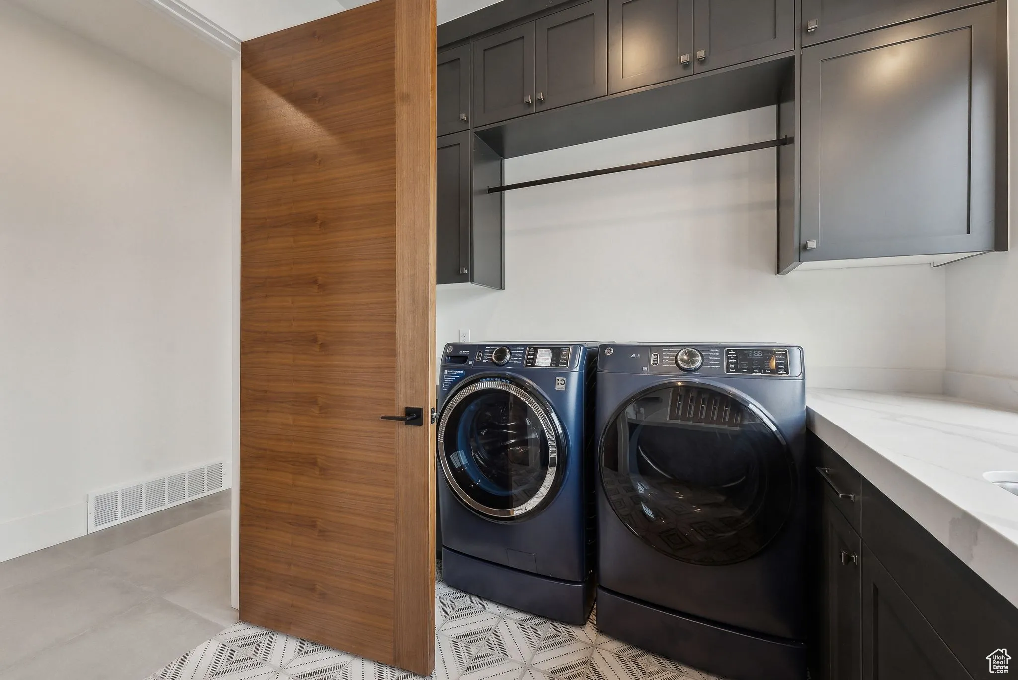 Laundry room with separate washer and dryer and cabinet space