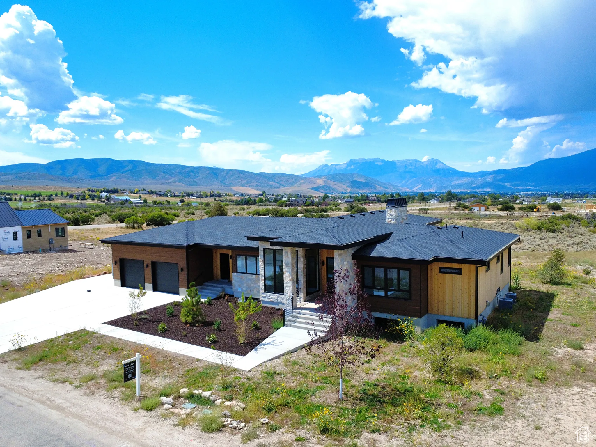 Prairie-style home with driveway, a mountain view, and a garage