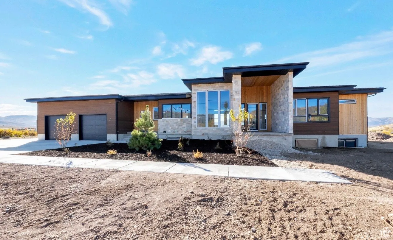 Contemporary house featuring driveway, covered porch, and a garage