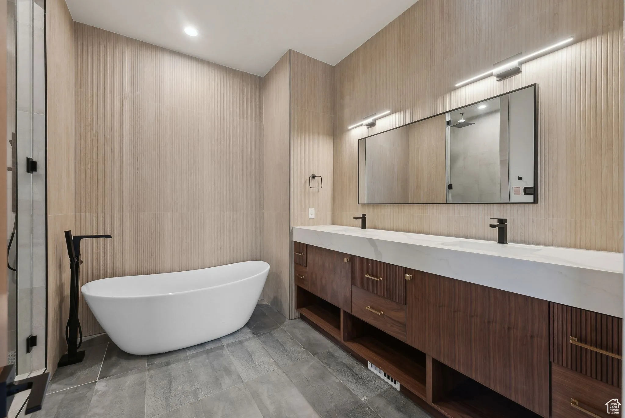 Full bathroom featuring tile walls, a freestanding tub, double vanity, a shower with door, and recessed lighting