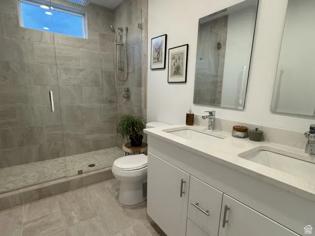 Full bath featuring double vanity and a stall shower