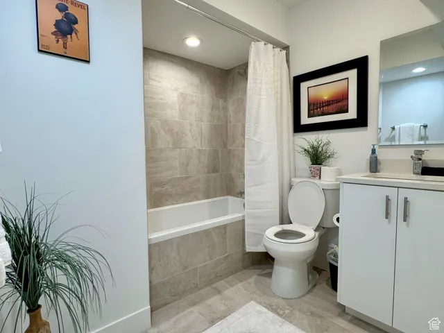 Full bath featuring vanity, tiled shower / bath combo, and recessed lighting