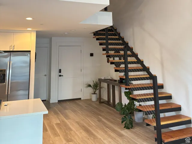 Entrance and stairway featuring wood finished floors and recessed lighting