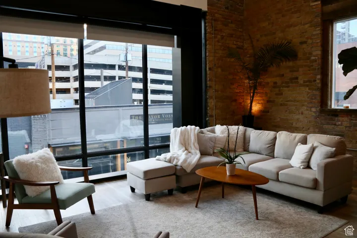 Living room featuring brick wall, wood finished floors, and a view of city