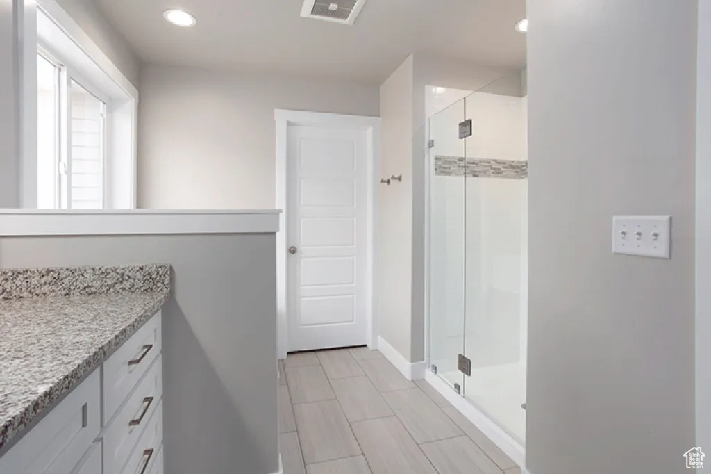 Full bath featuring a stall shower, vanity, and recessed lighting