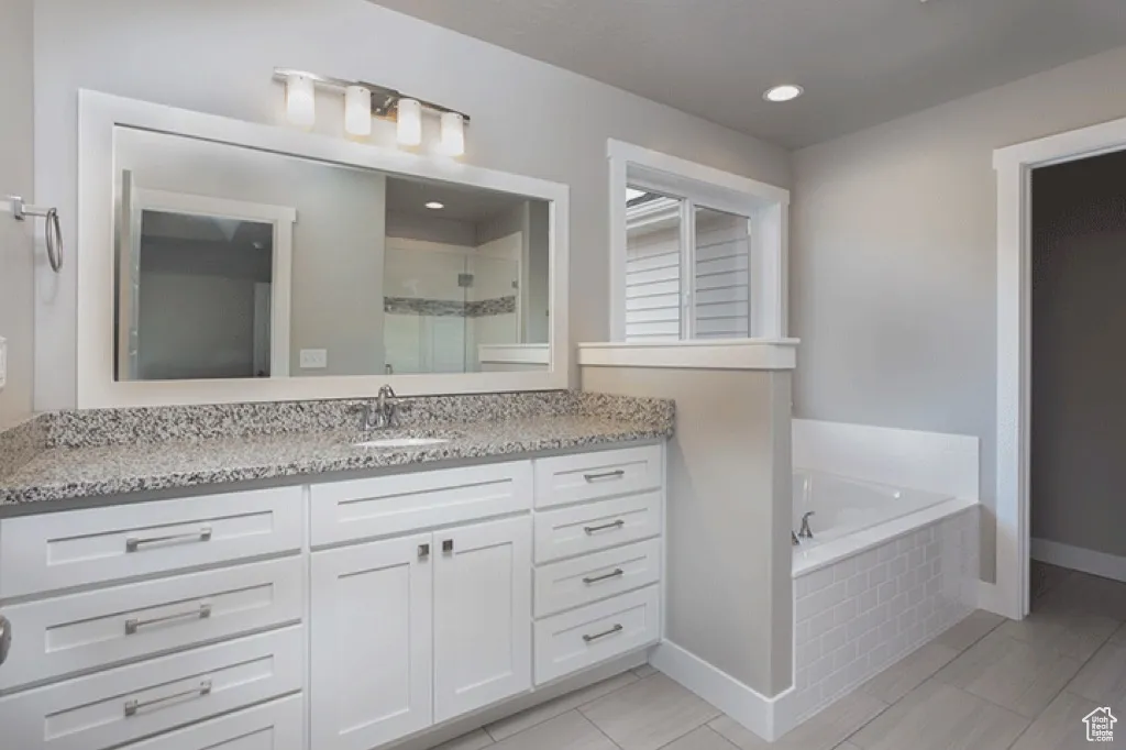 Full bath featuring vanity, a shower stall, a garden tub, and recessed lighting