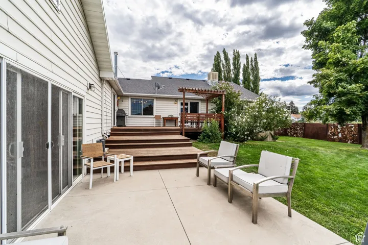 Fenced backyard featuring a deck, a patio, and a pergola