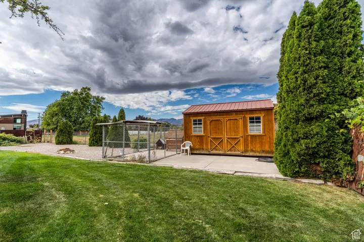 View of yard featuring an outbuilding, a patio, and an exterior structure