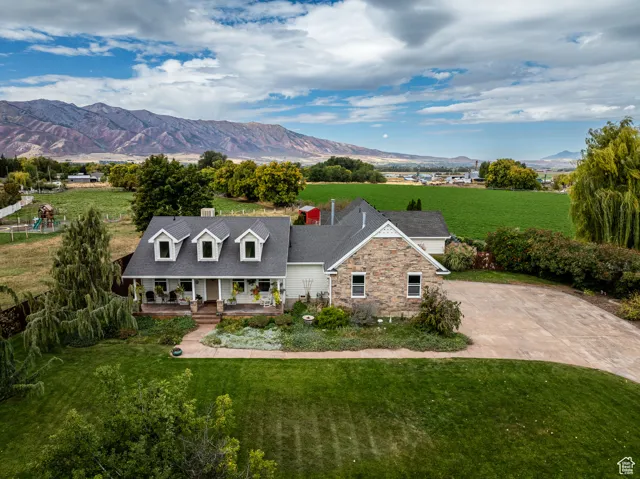 View of front of property featuring a covered porch, a front yard, a mountain view, and concrete driveway