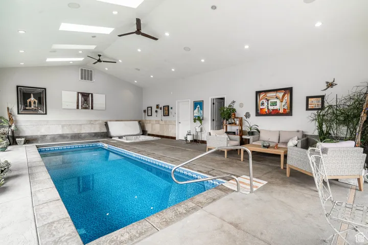 Indoor pool with a skylight and ceiling fan
