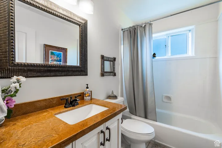 Bathroom with shower / bathtub combination with curtain and vanity