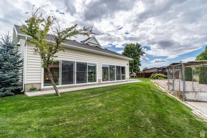 Rear view of property with a sunroom with pool.