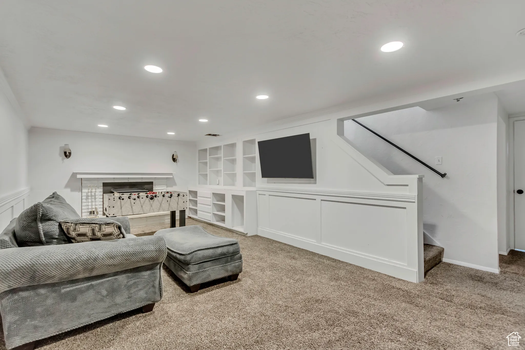 Living room with carpet floors, recessed lighting, stairs, built in shelves, and ornamental molding