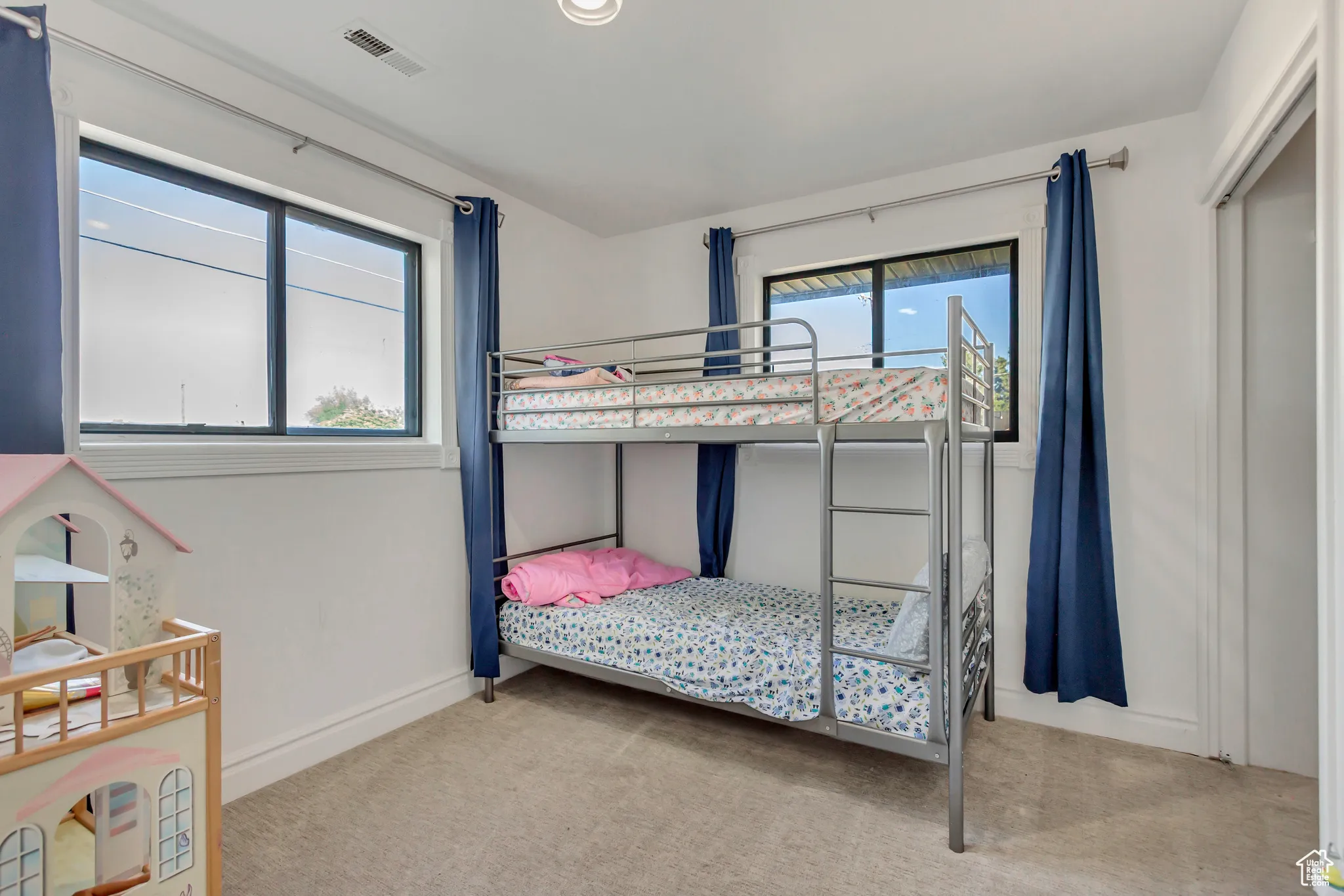 Bedroom featuring light carpet and baseboards