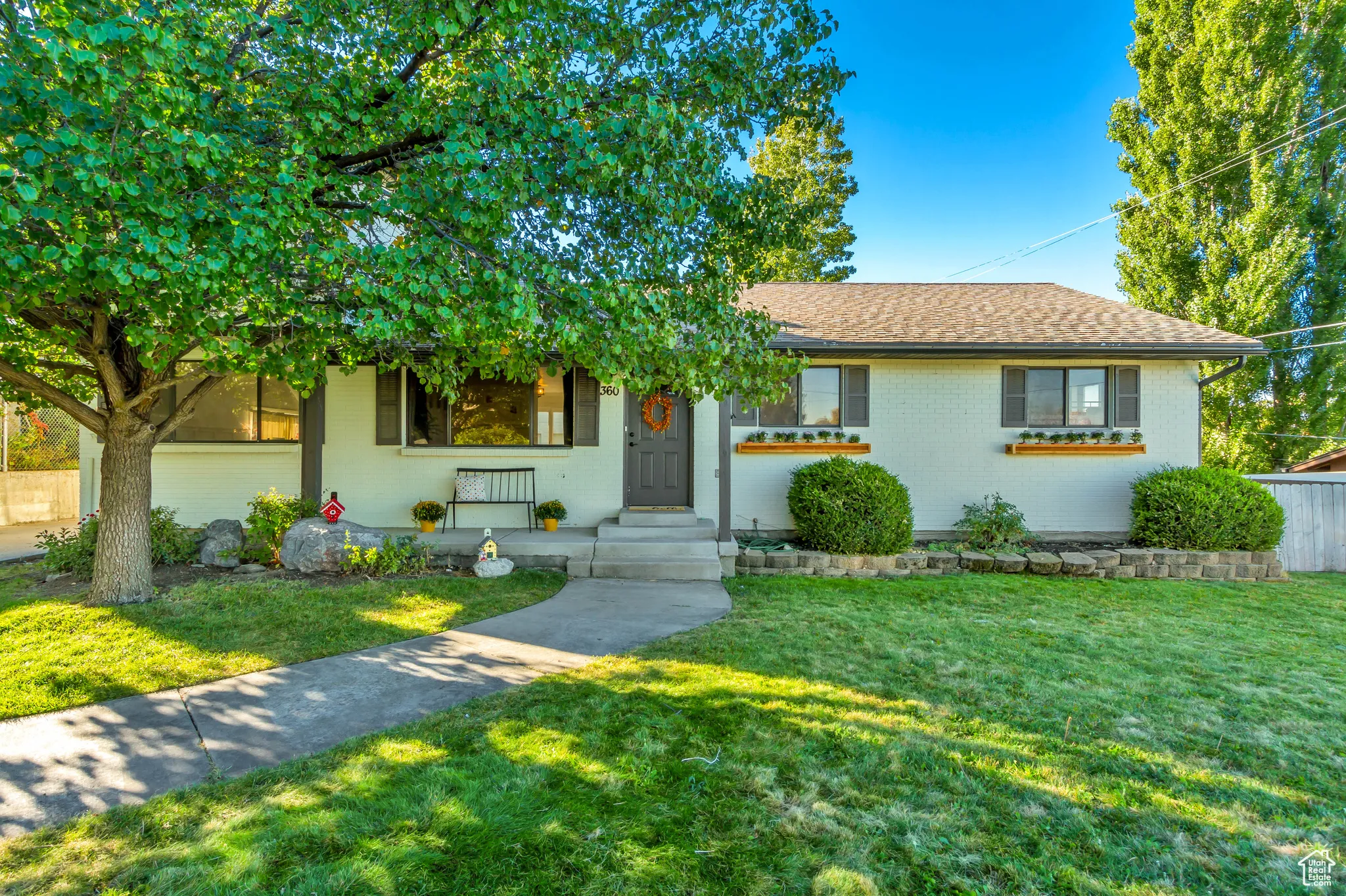 Single story home with a front yard, brick siding, and a shingled roof