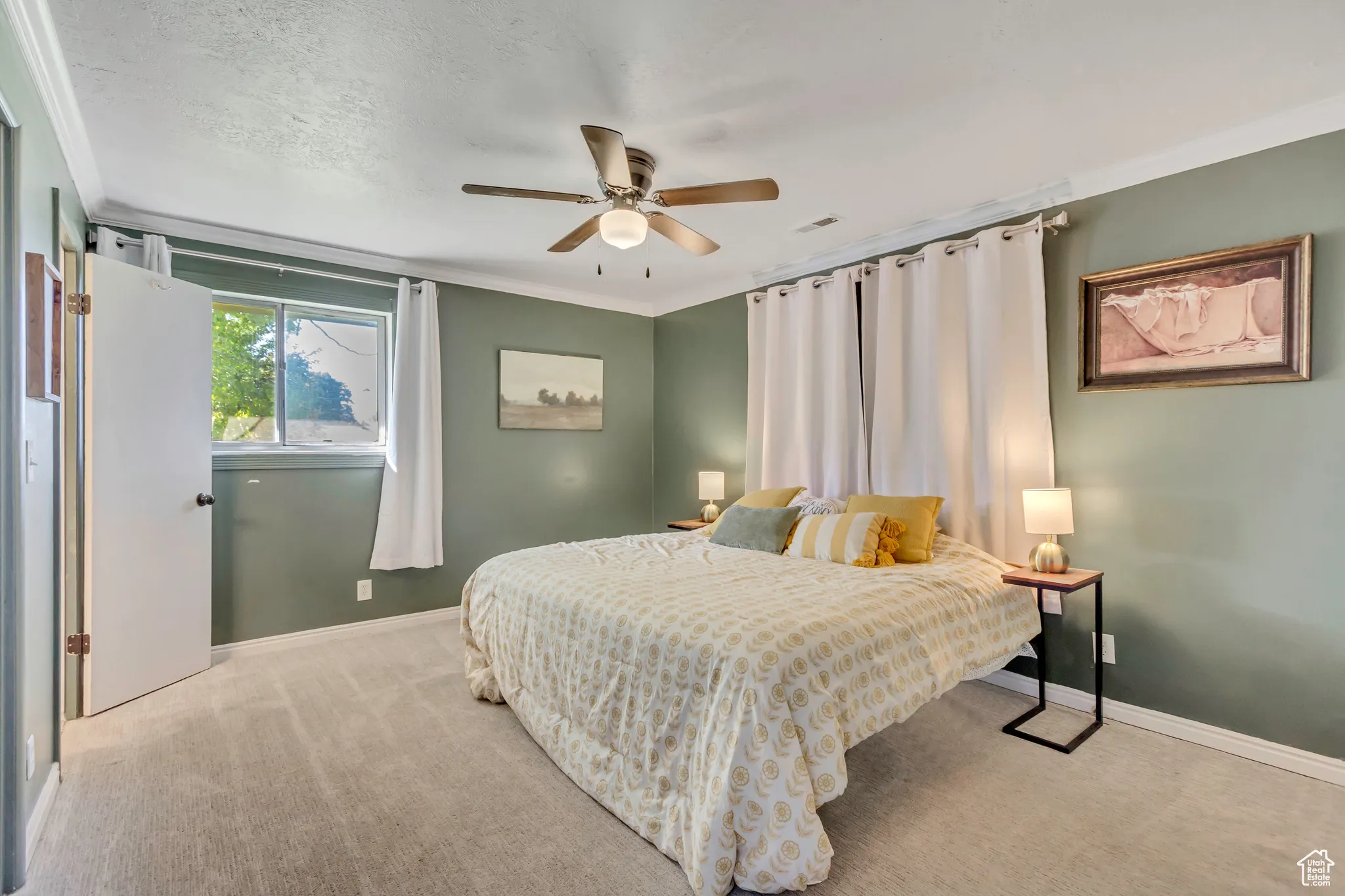 Bedroom featuring crown molding, light carpet, and a ceiling fan
