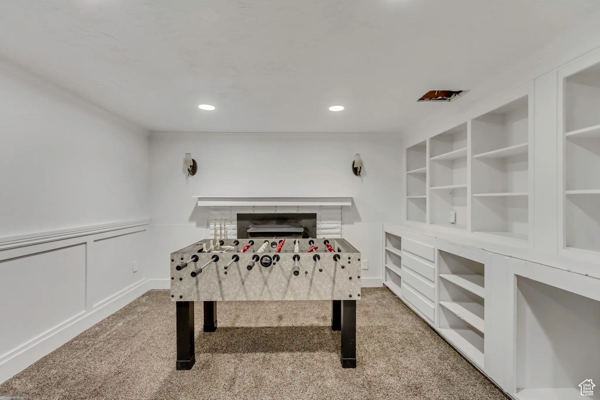 Rec room with light colored carpet, recessed lighting, crown molding, a decorative wall, and a wainscoted wall