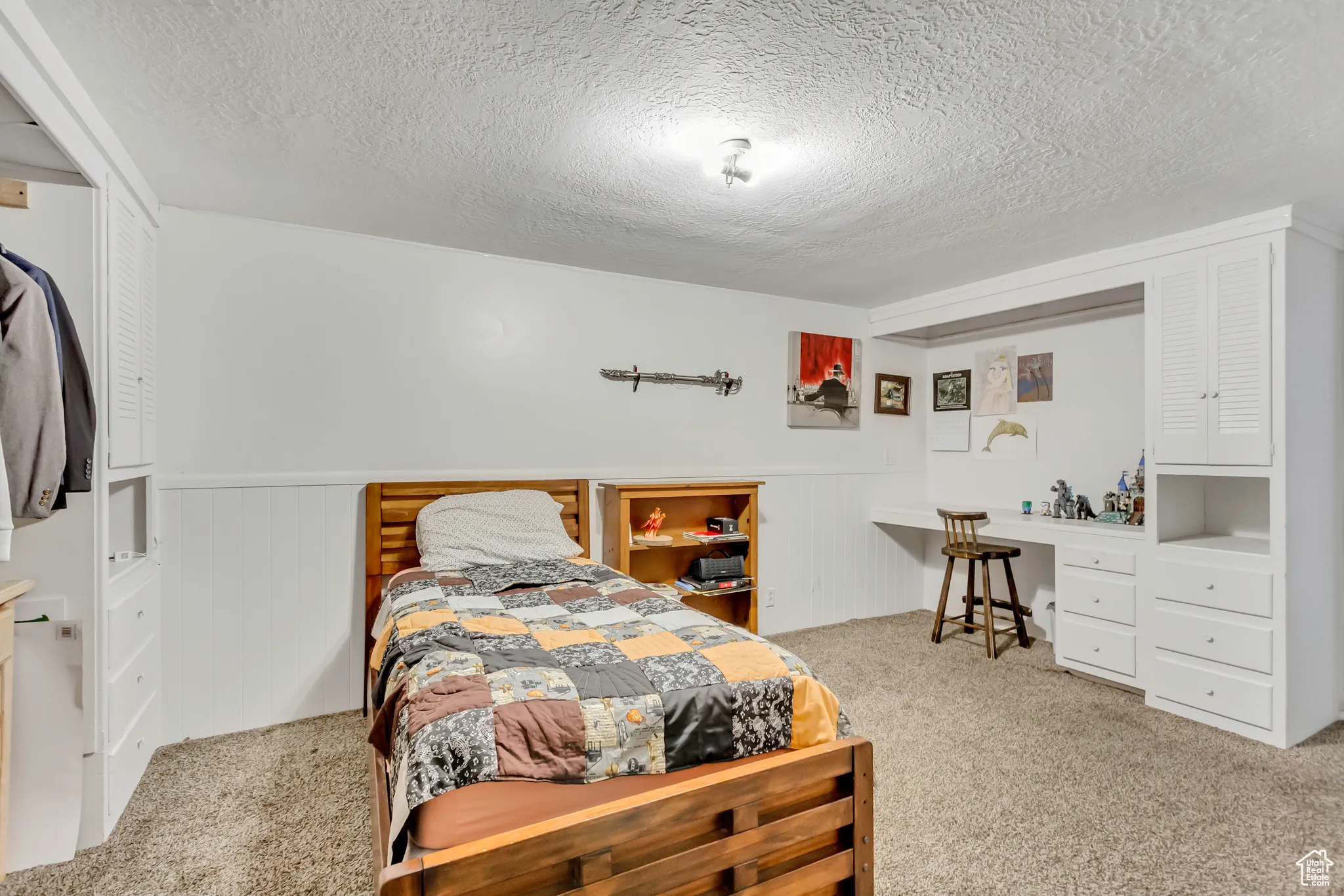 Bedroom with light colored carpet and a textured ceiling