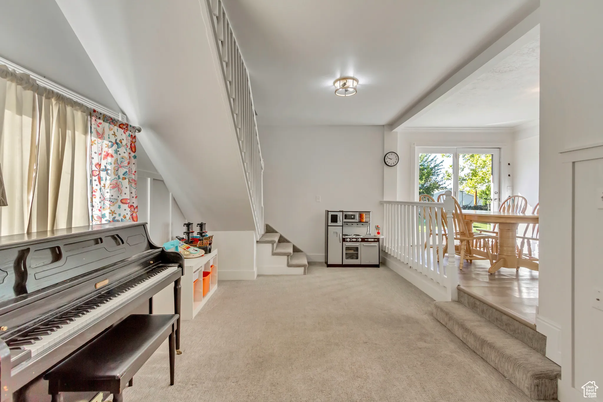 Sitting room with light colored carpet and stairway