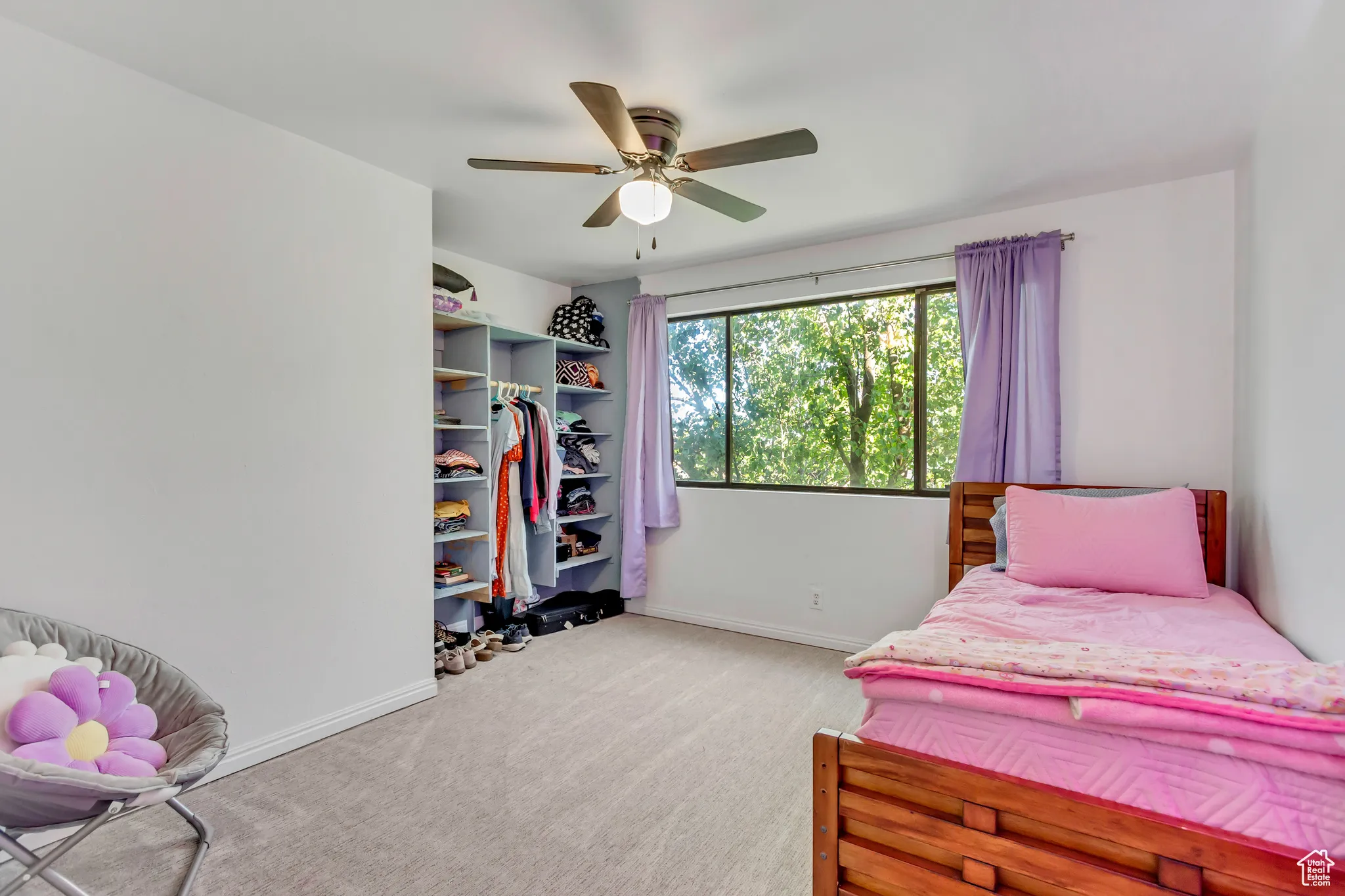 Bedroom with light carpet and a ceiling fan