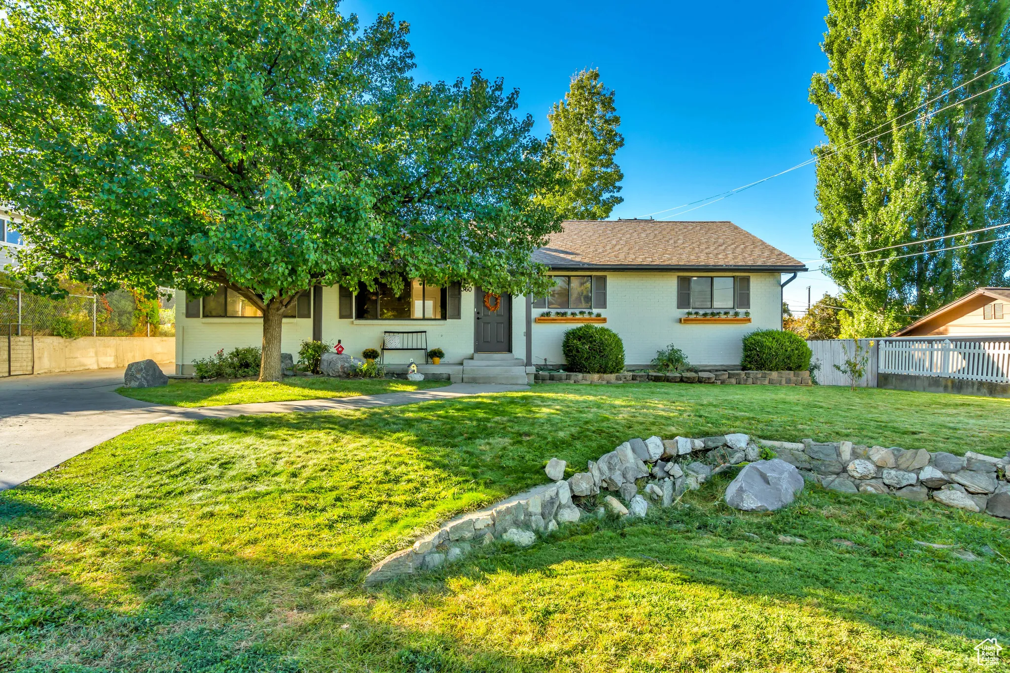 View of front of home featuring a shingled roof and concrete driveway