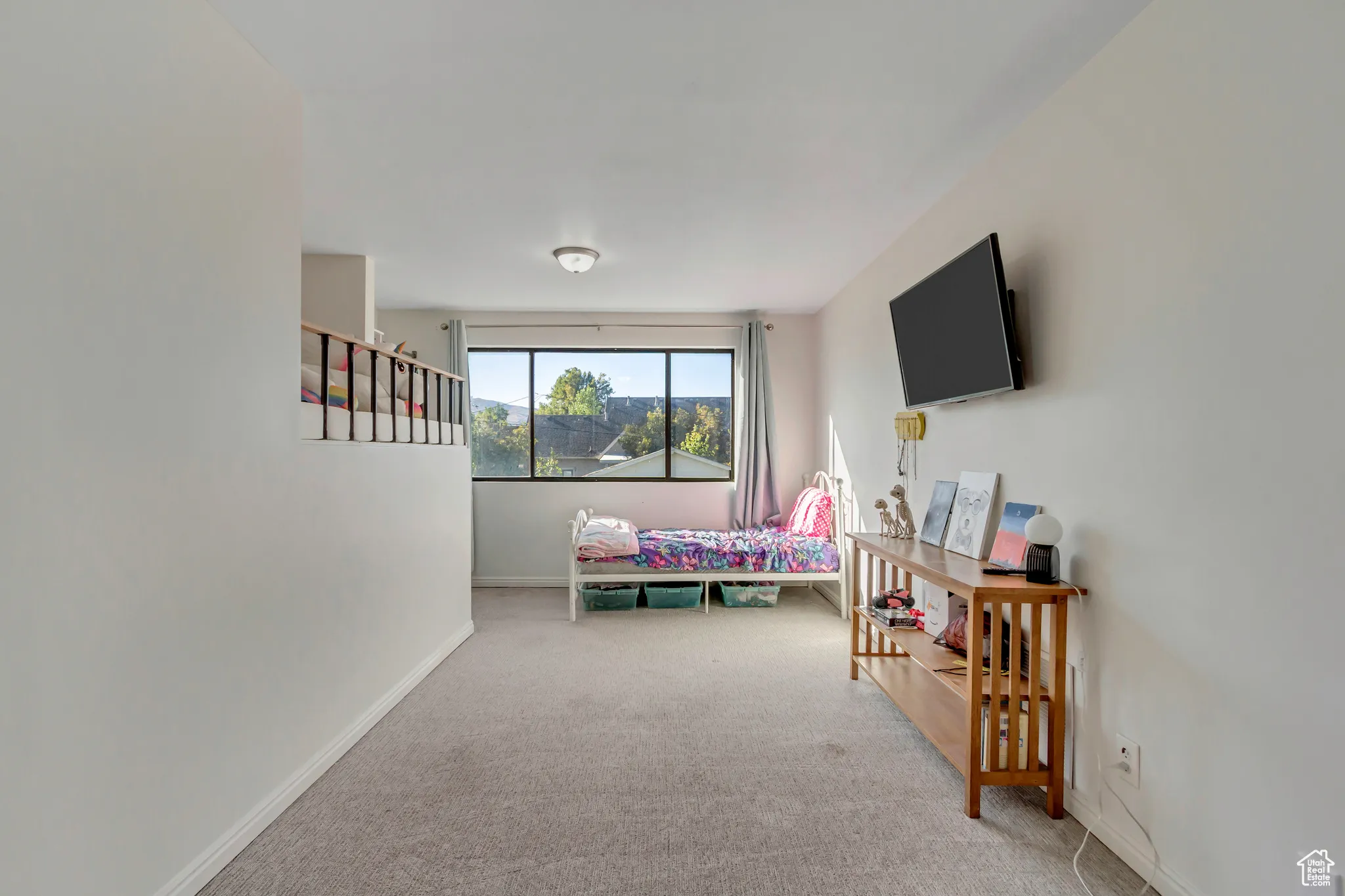 Bedroom featuring light carpet and baseboards