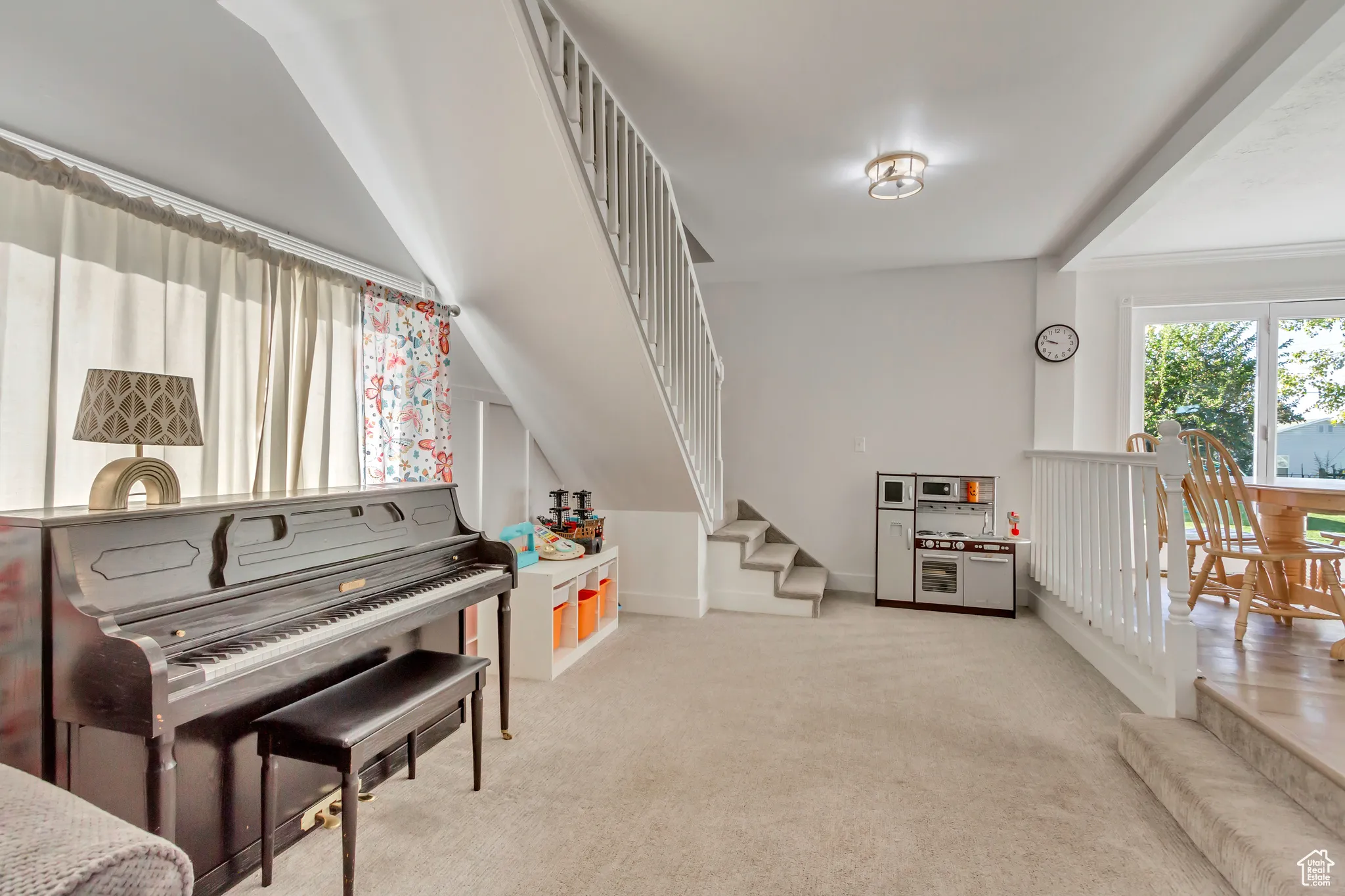 Living area featuring stairs and light carpet