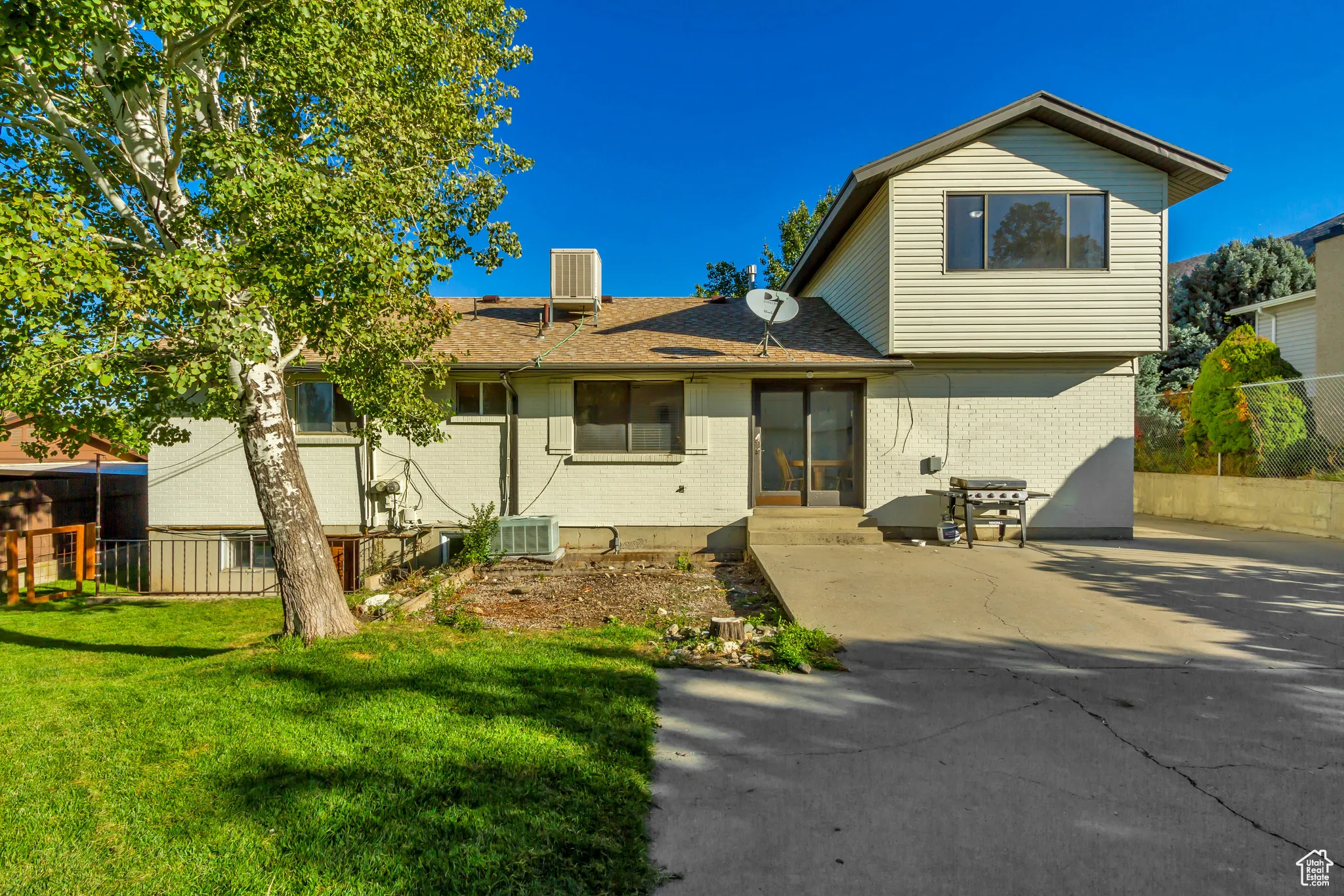 Rear view of property with brick siding and roof with shingles