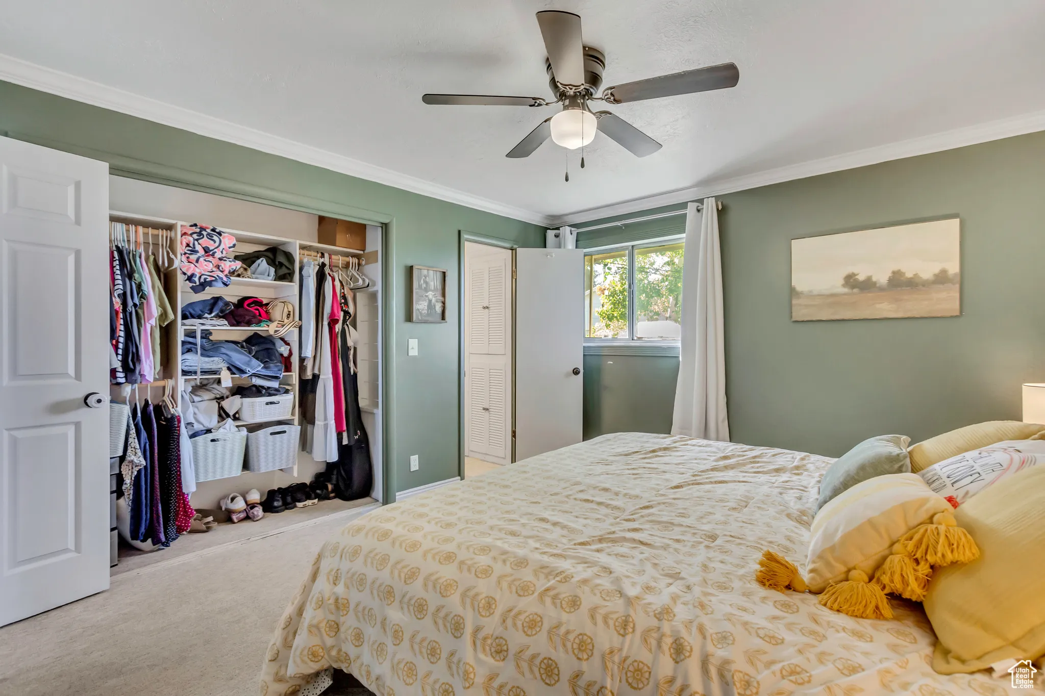 Bedroom featuring crown molding, carpet floors, a closet, and a ceiling fan