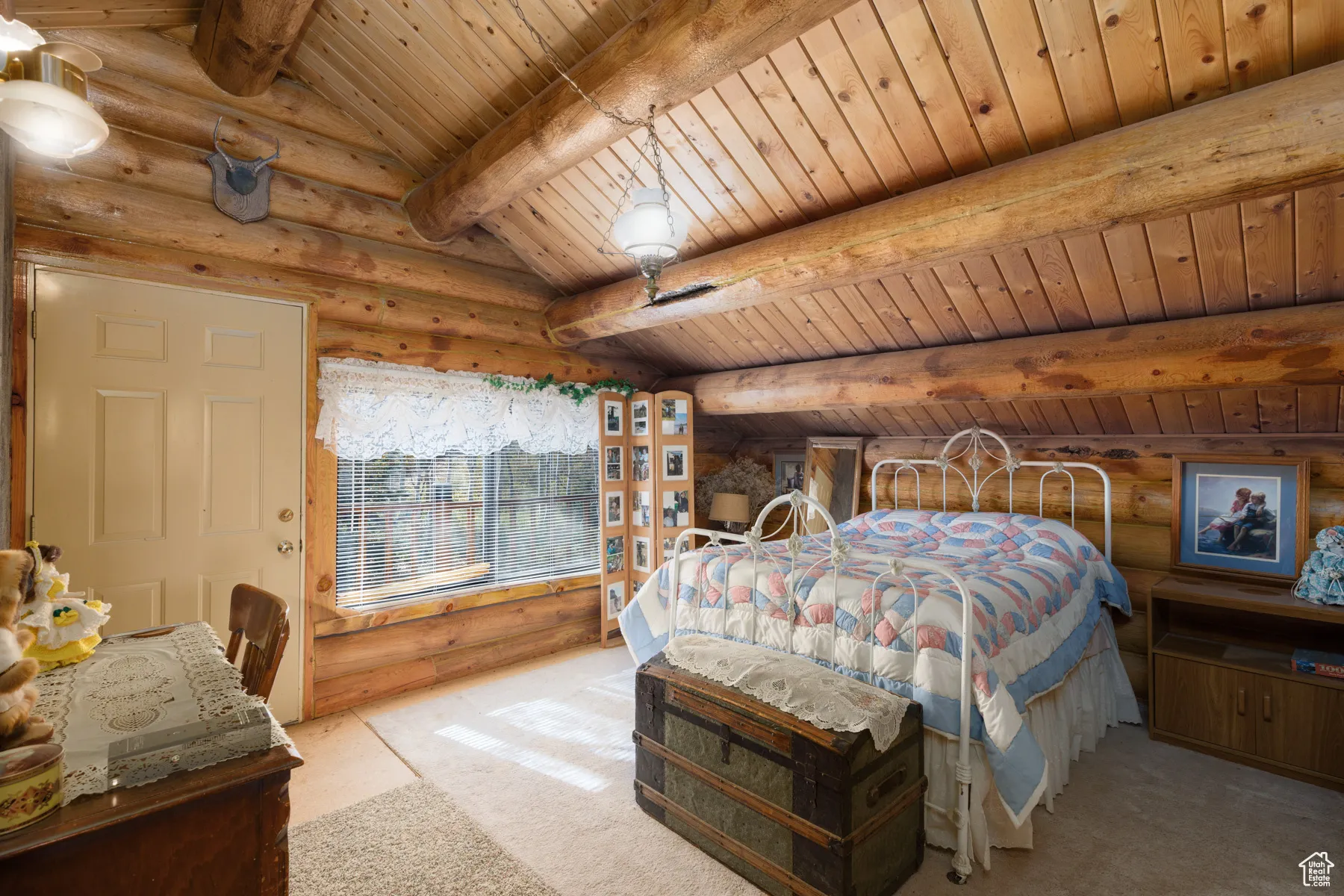 Bedroom featuring log walls, carpet, and wooden ceiling