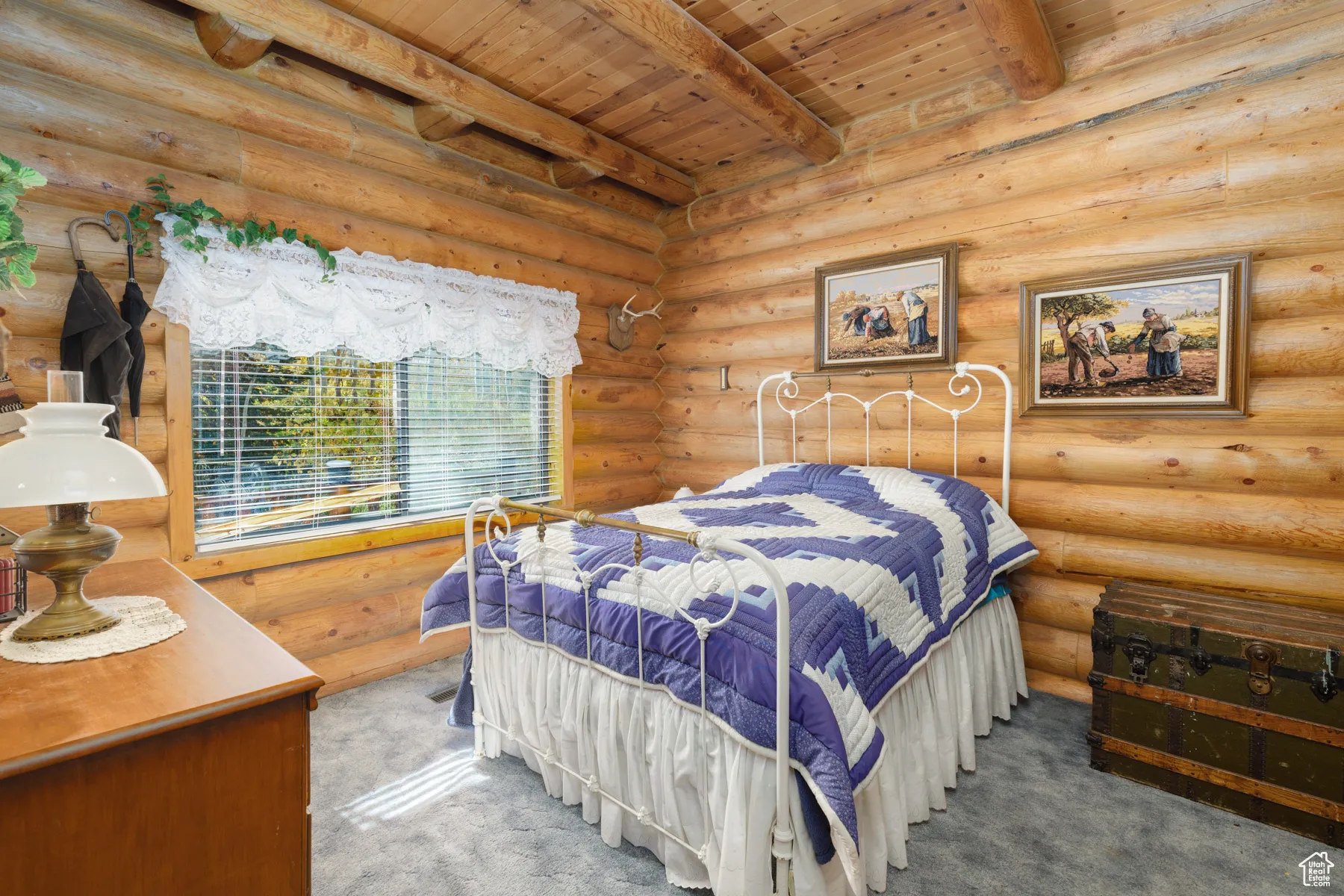 Bedroom with carpet floors, a wood ceiling with exposed beams, and rustic walls
