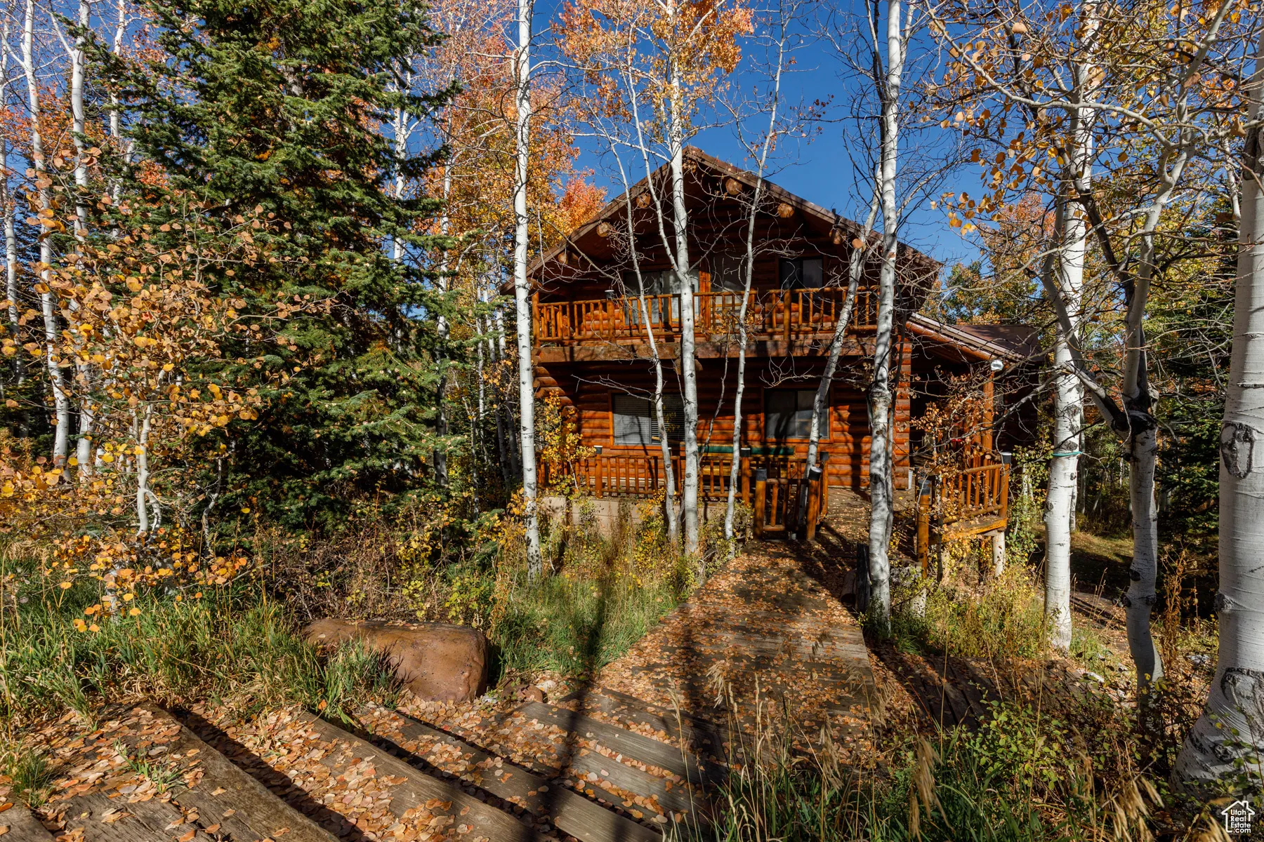 Back of property featuring log veneer siding and a deck