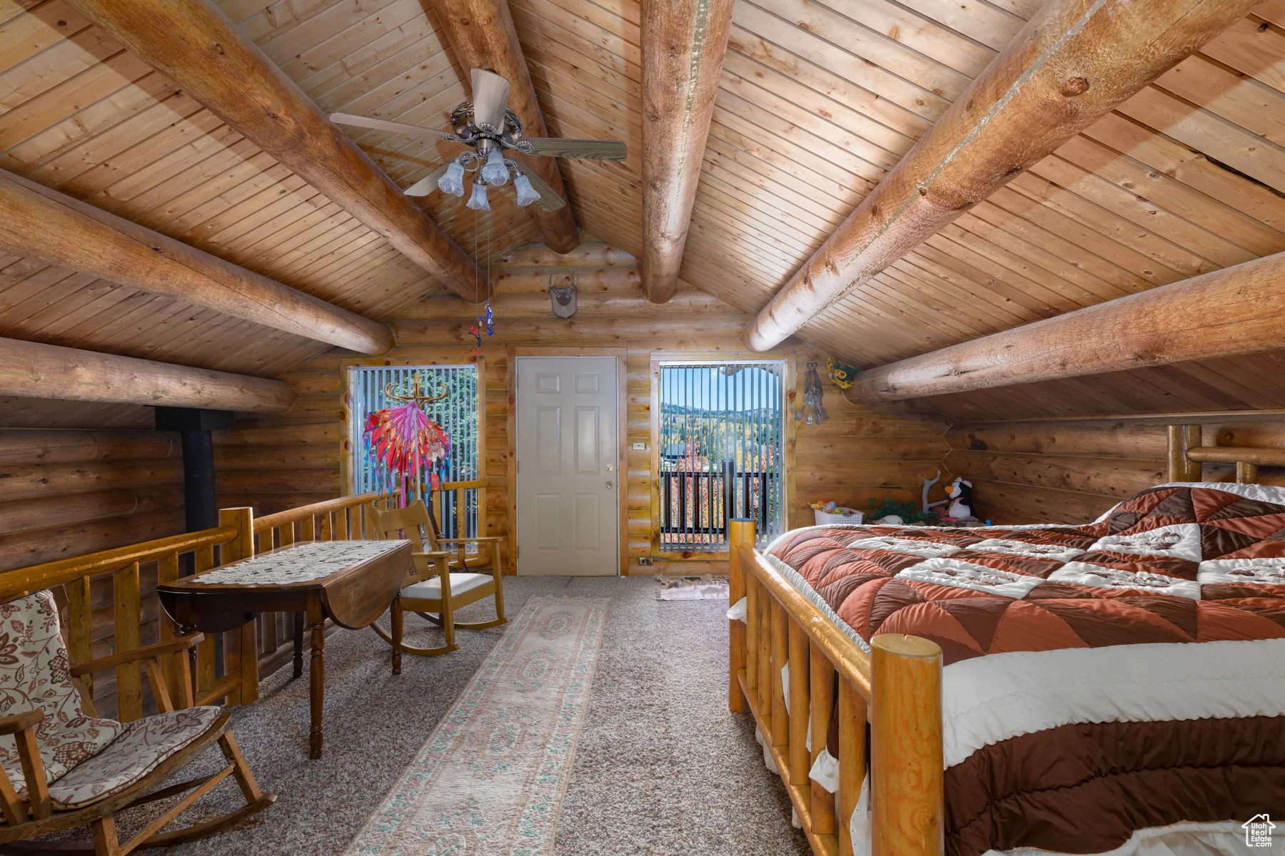 Bedroom with log walls, carpet, a wood stove, and wood ceiling