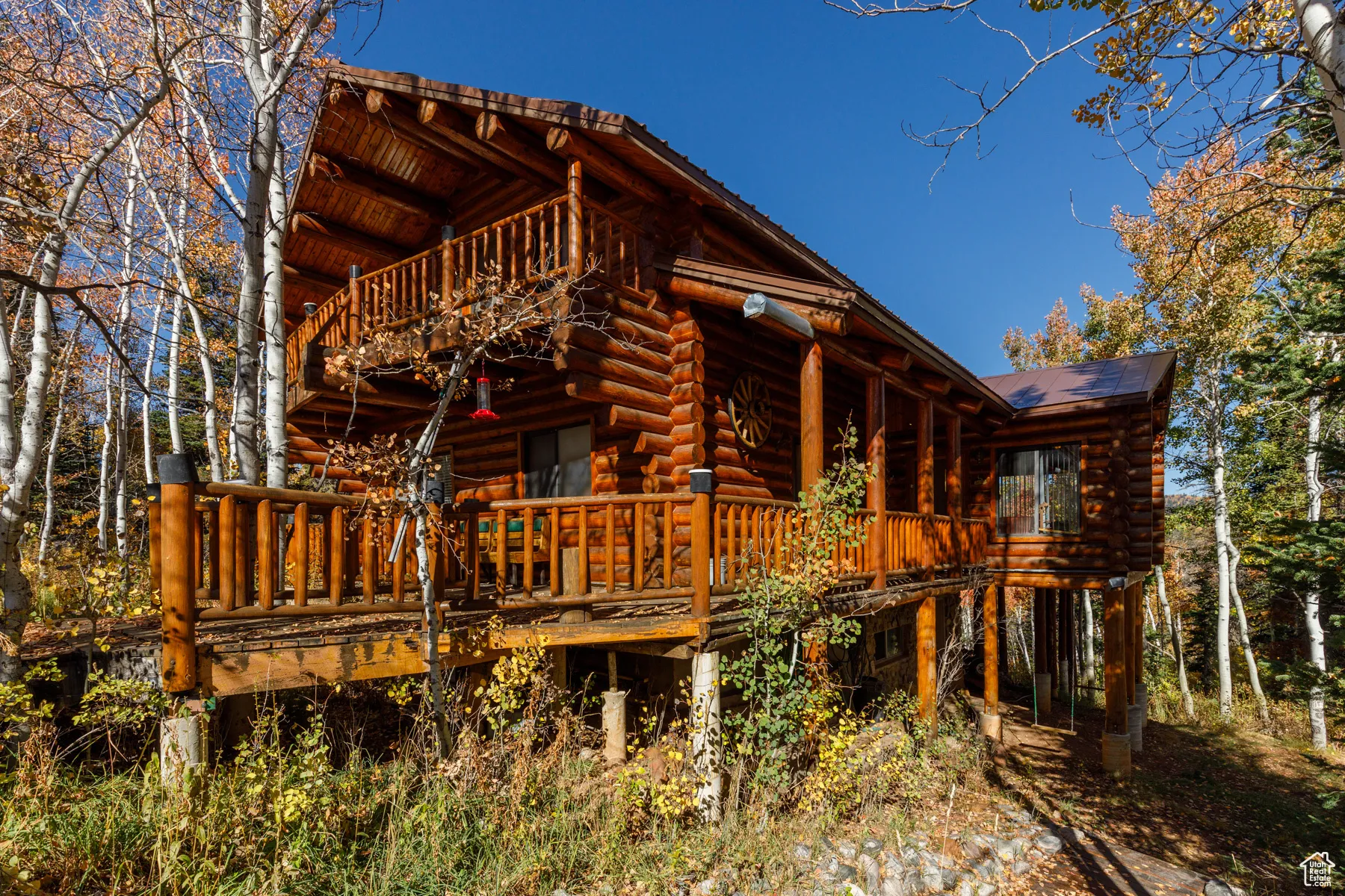Rear view of property featuring log siding, a deck, and a balcony