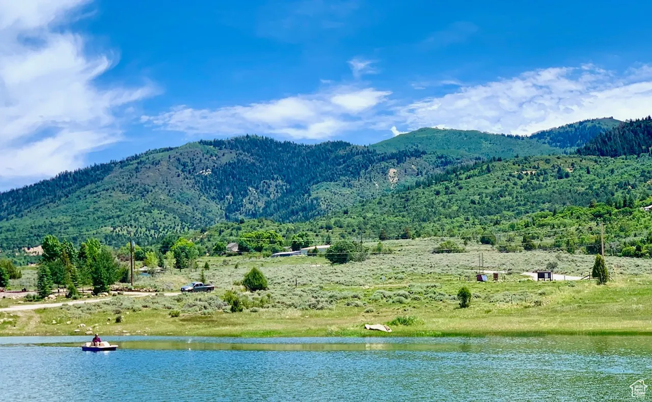 View of mountain backdrop featuring a large body of water and rural landscape