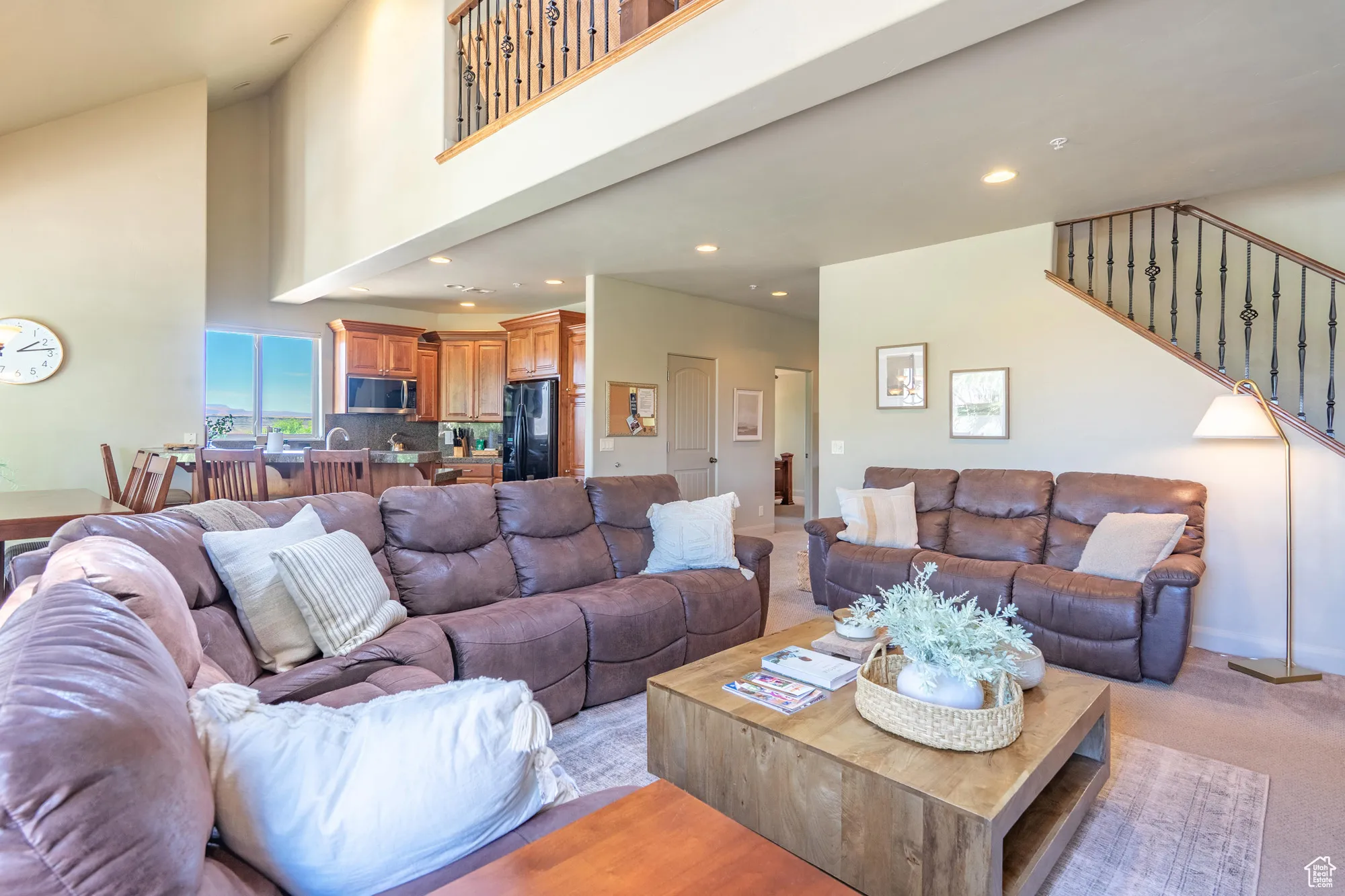 Living area featuring a towering ceiling, carpet, recessed lighting, and stairway