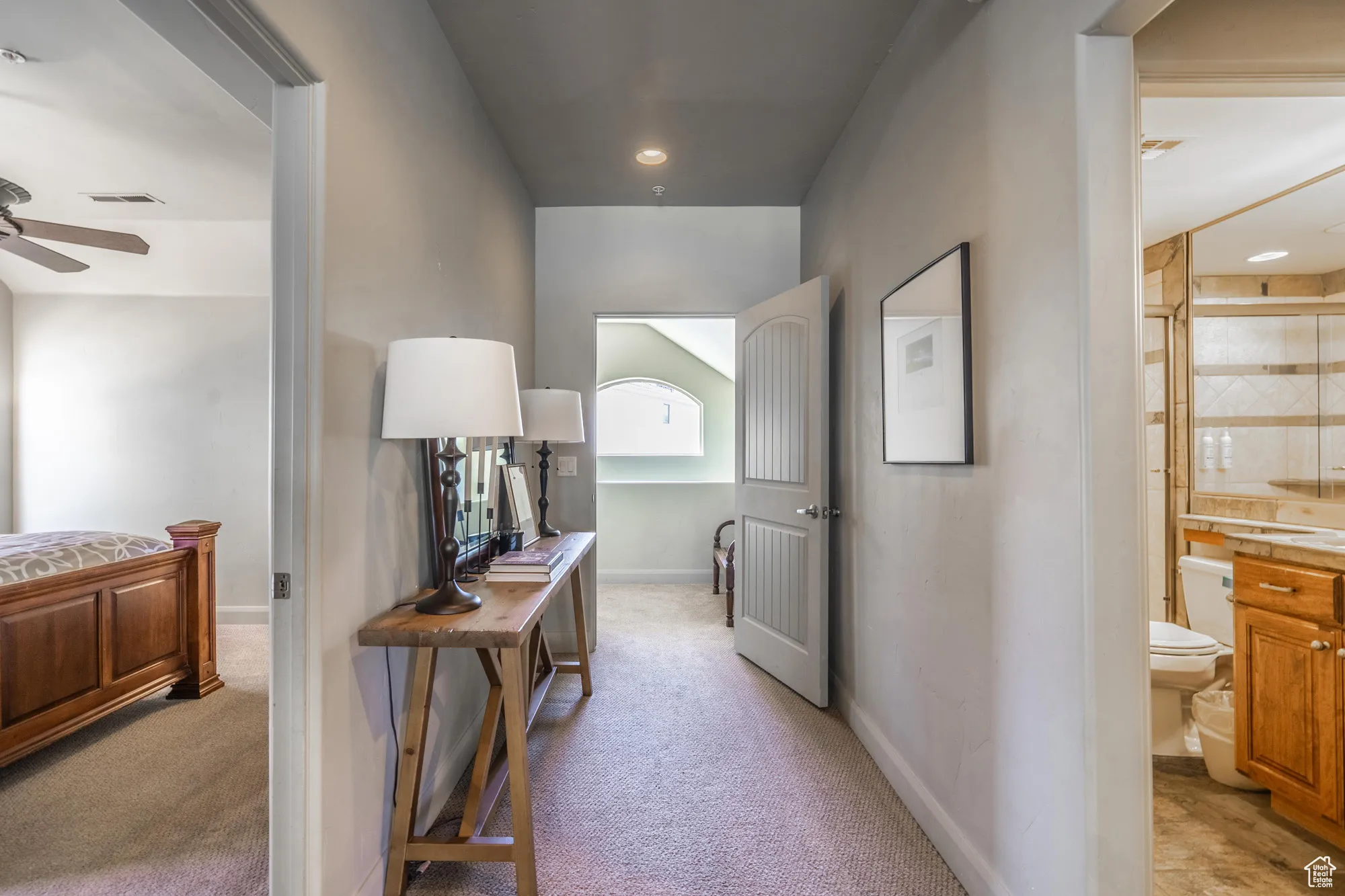 Hall with light colored carpet and baseboards