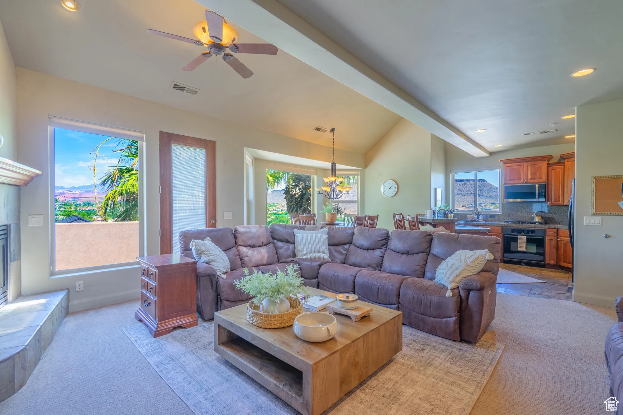 Living area with recessed lighting, ceiling fan, a tiled fireplace, a chandelier, and light colored carpet