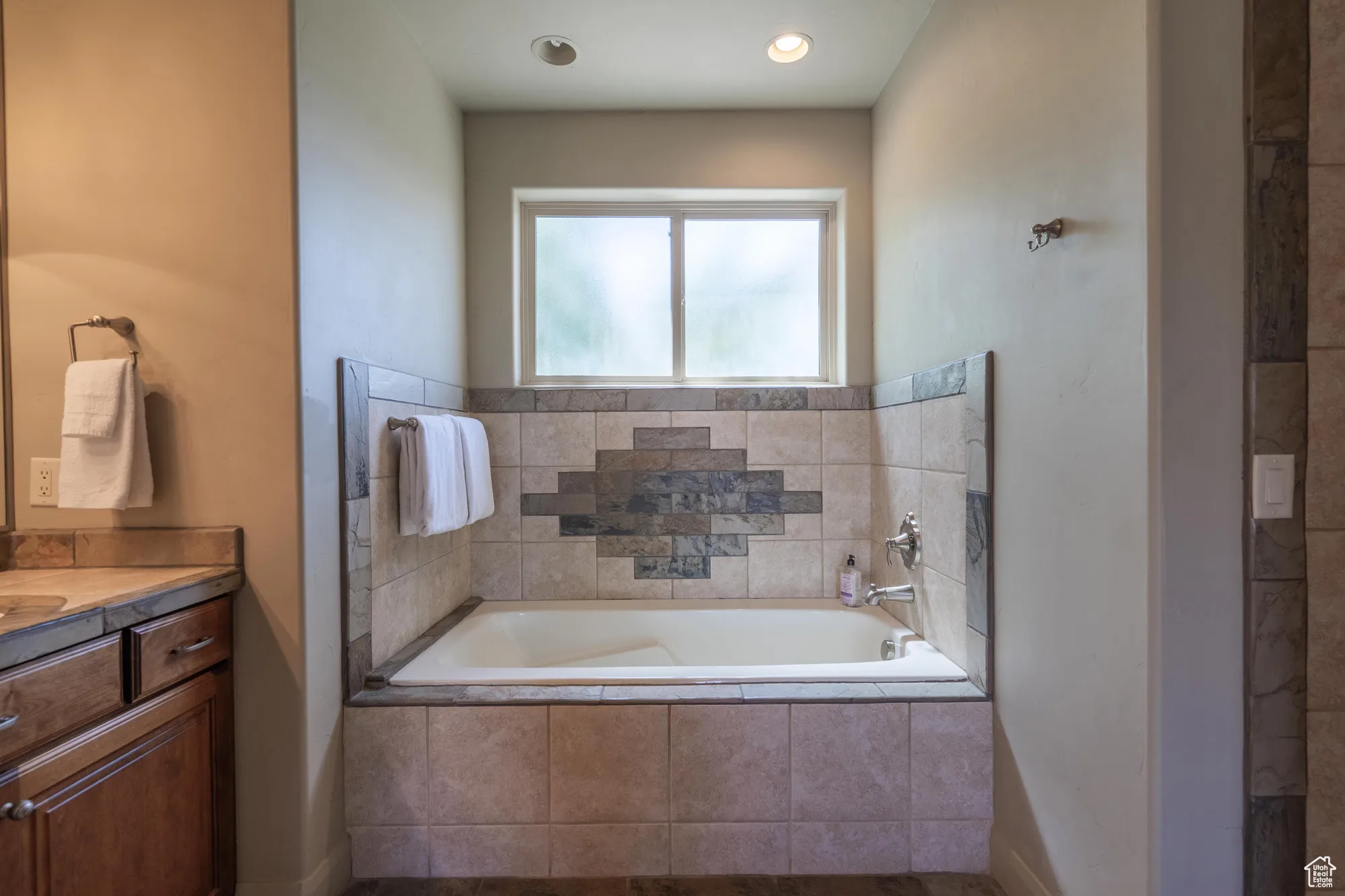 Full bath with vanity and a garden tub