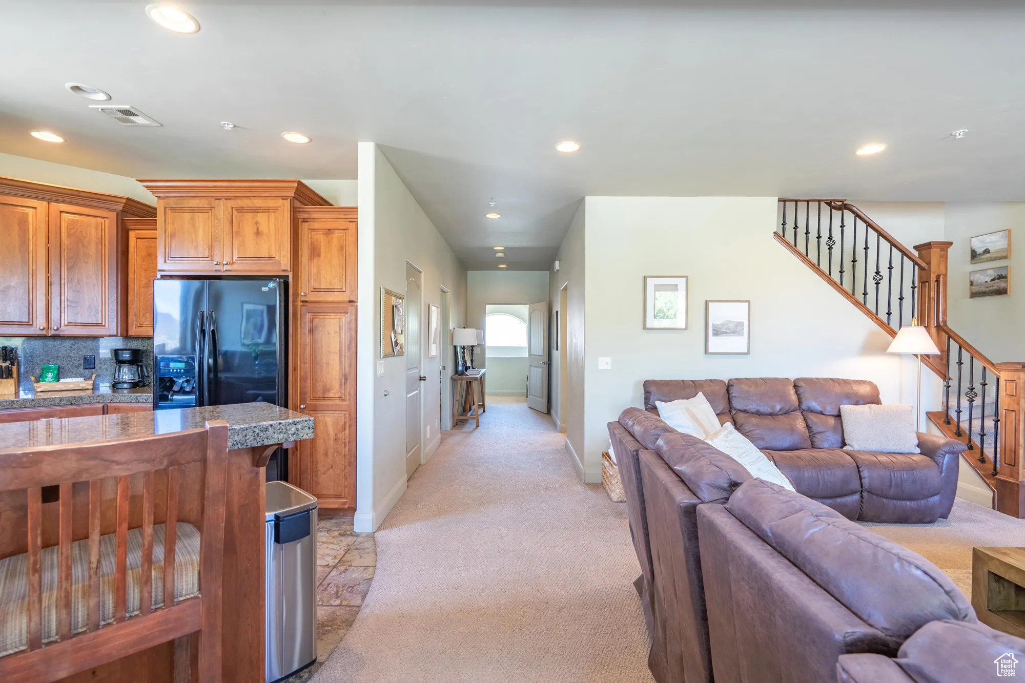 Living area with recessed lighting, light colored carpet, and stairs
