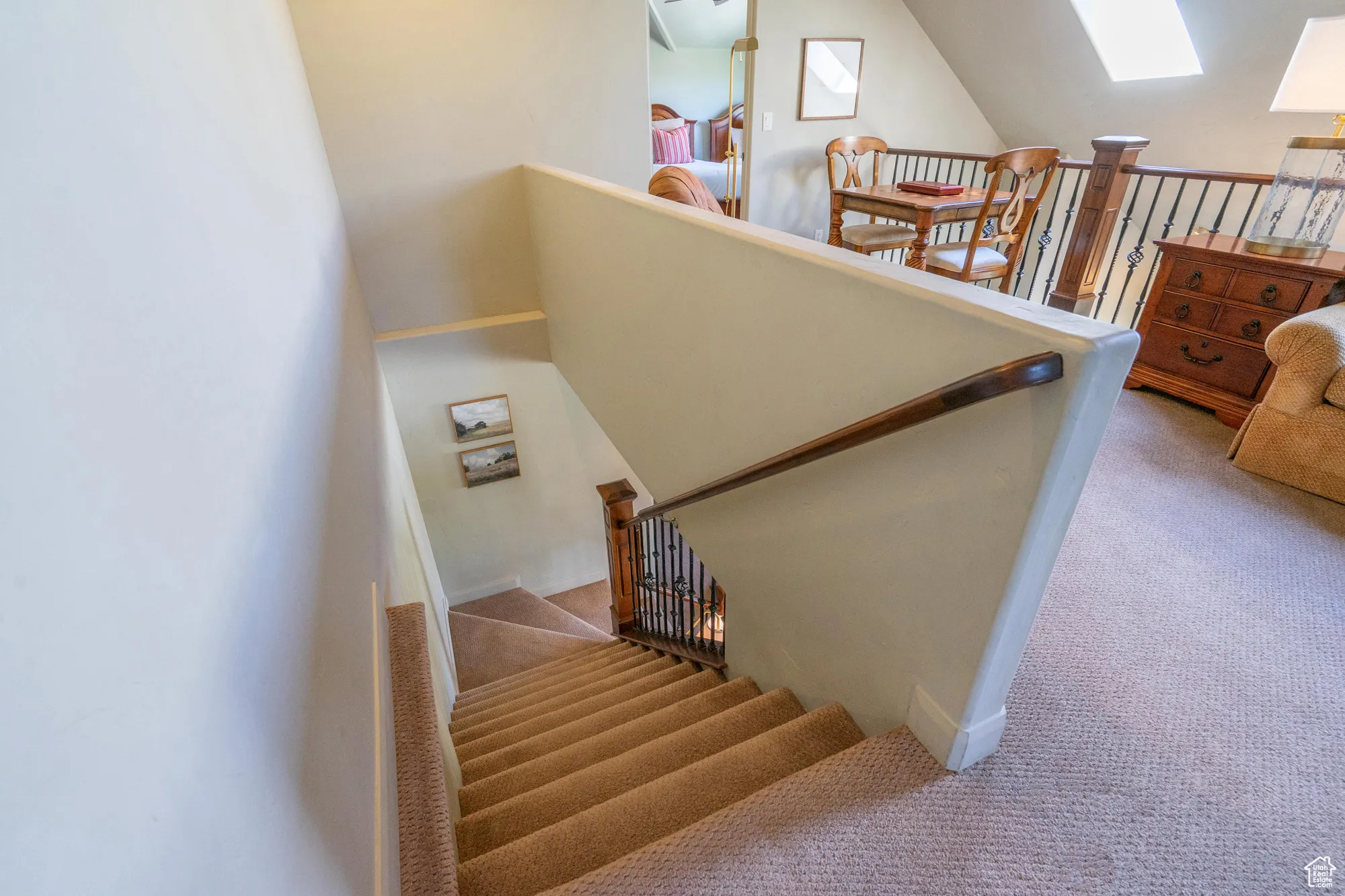 Staircase featuring carpet floors, vaulted ceiling, and a skylight