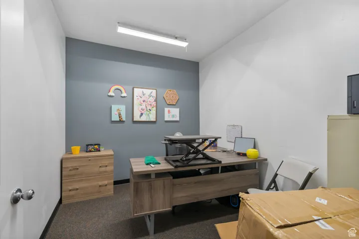 Office space with dark carpet and baseboards