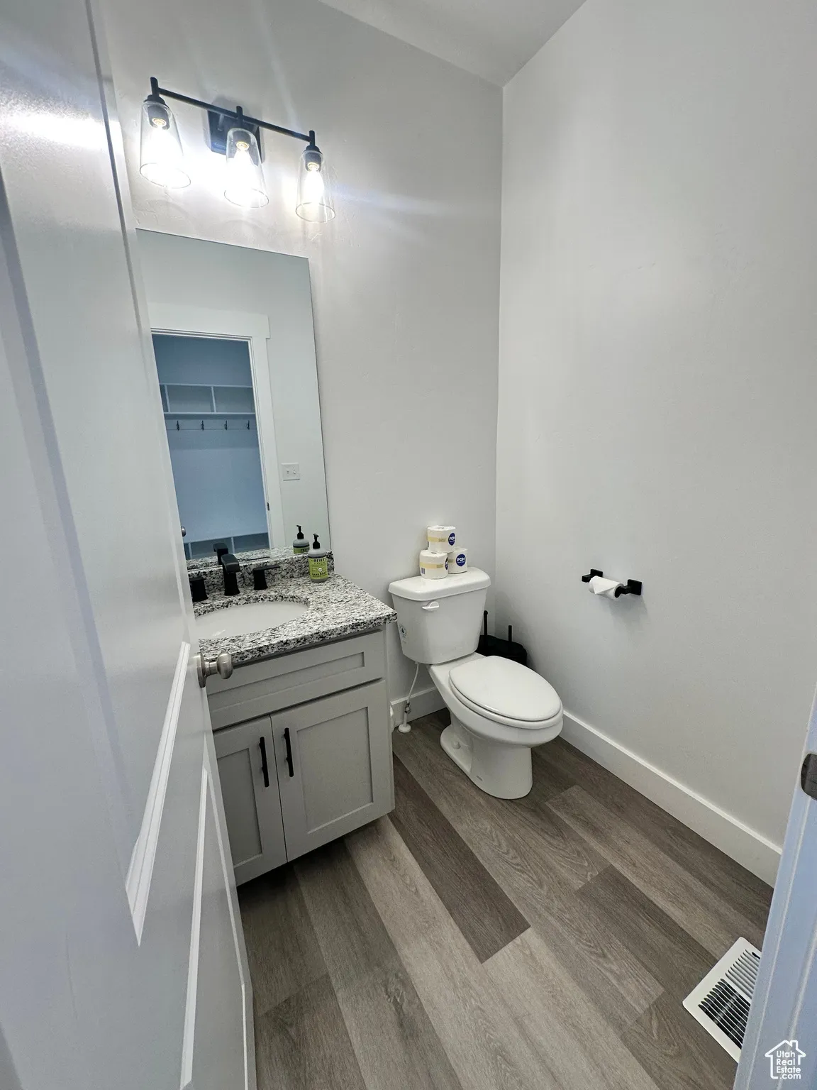 Half bathroom featuring light wood finished floors and vanity