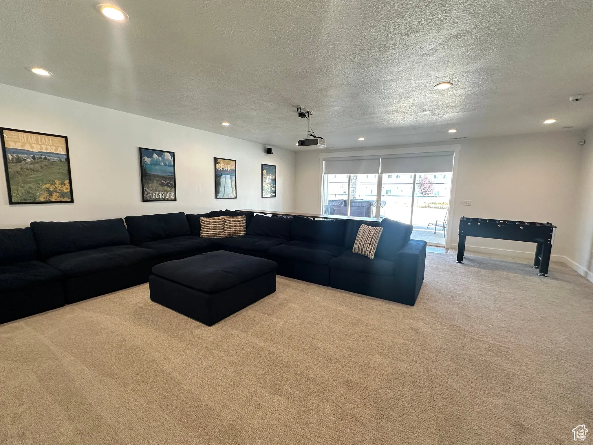 Carpeted living room with a textured ceiling and recessed lighting
