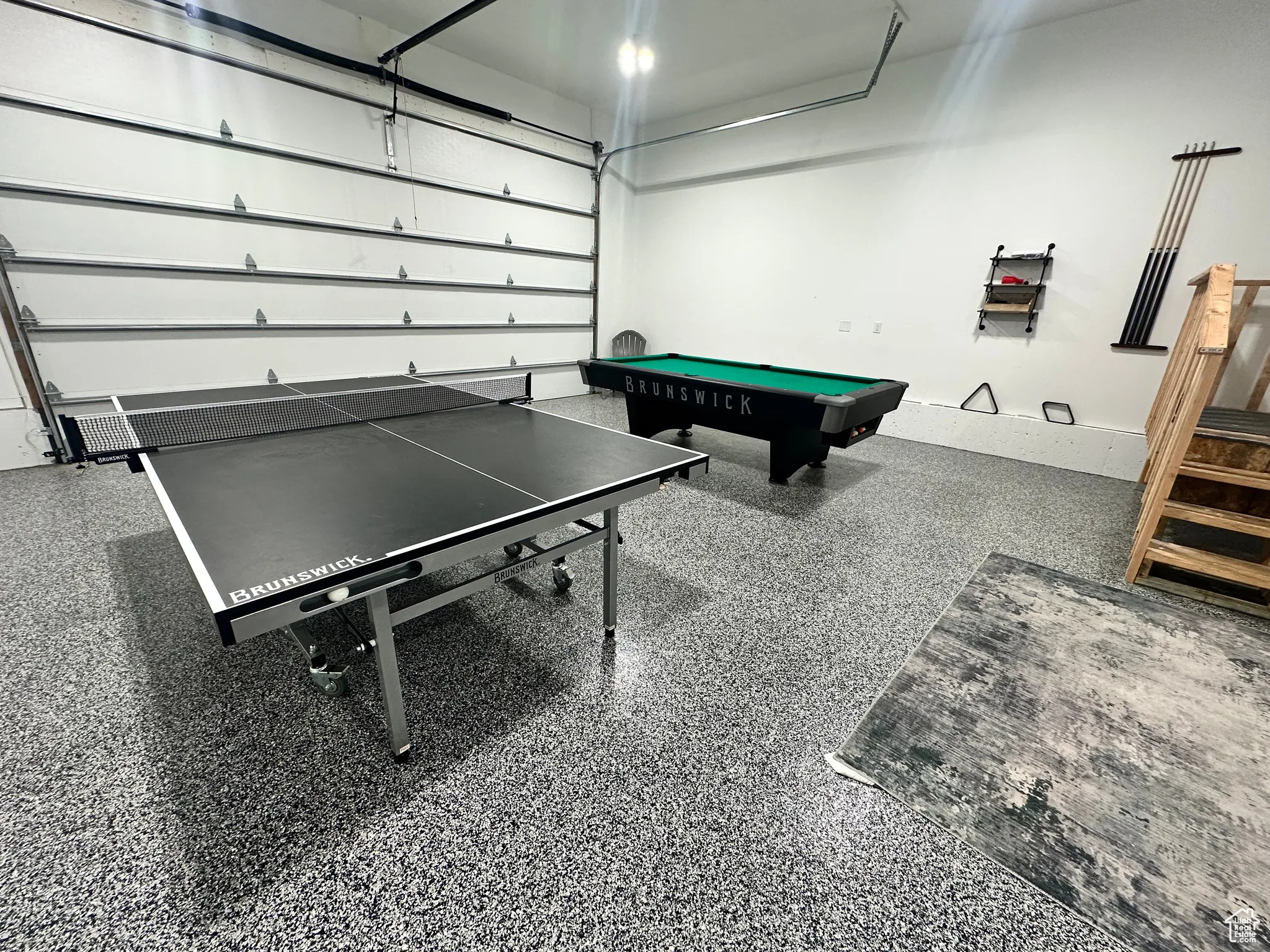 Recreation room featuring a garage, speckled floor, and billiards table
